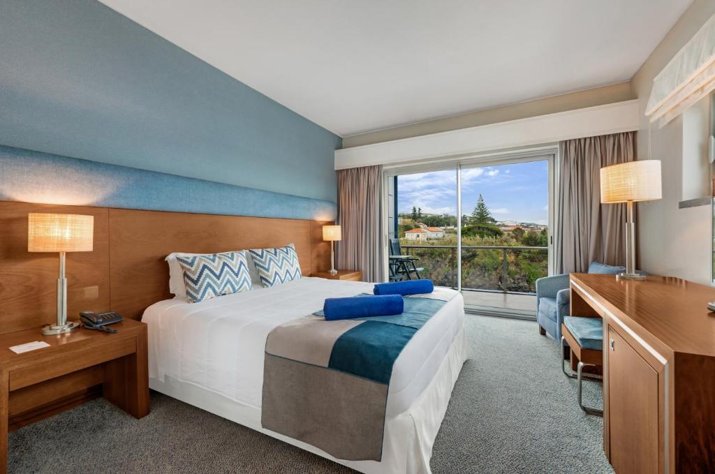 a hotel room with a bed and a window at Hotel Do Caracol in Angra do Heroísmo