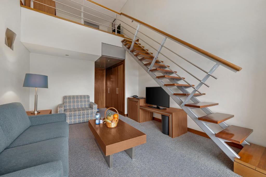 a living room with a couch and a staircase at Hotel Do Caracol in Angra do Heroísmo
