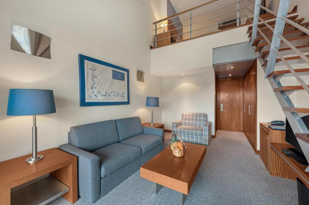 a living room with a couch and a staircase at Hotel Do Caracol in Angra do Heroísmo