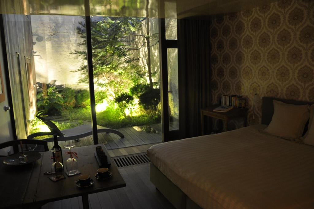a bedroom with a bed and a view of a garden at Schopenhauer in Ghent