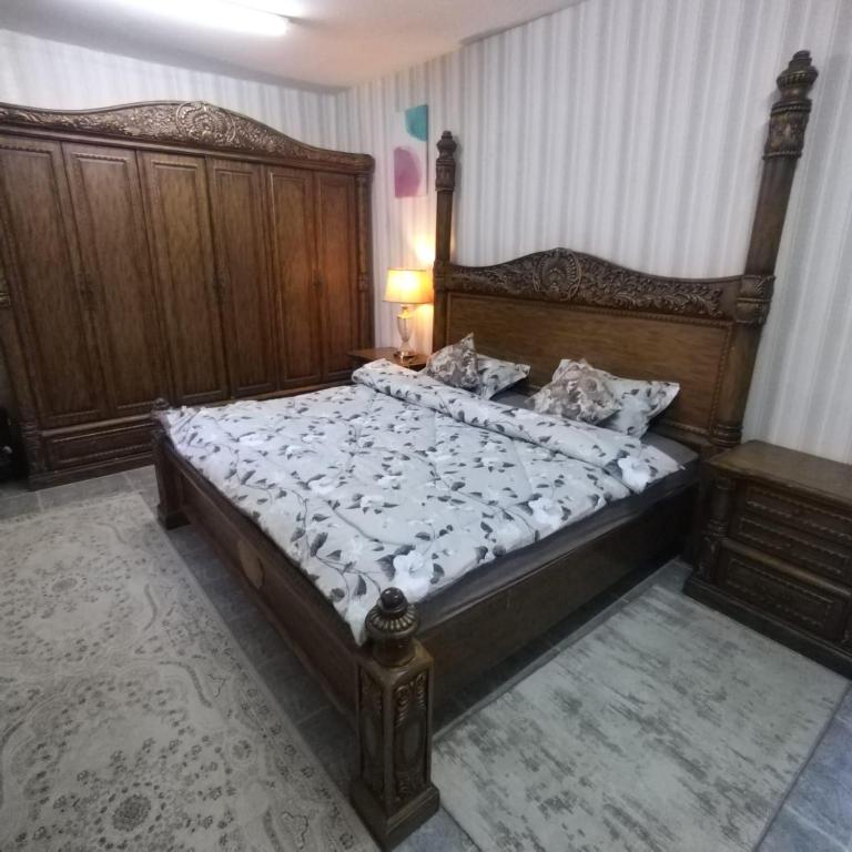 una camera con un grande letto con testiera in legno di العين الهيلي مصباح ب 7 a Al Ain