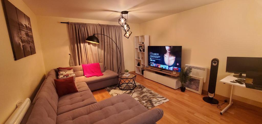 ein Wohnzimmer mit einem Sofa und einem Flachbild-TV in der Unterkunft Luxurious and spacious 1 bd flat in Basildon
