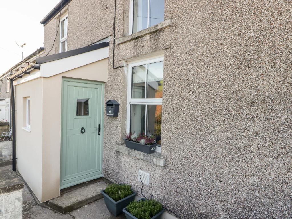 a house with a green door and a window at Golygfa Bryn in Porth