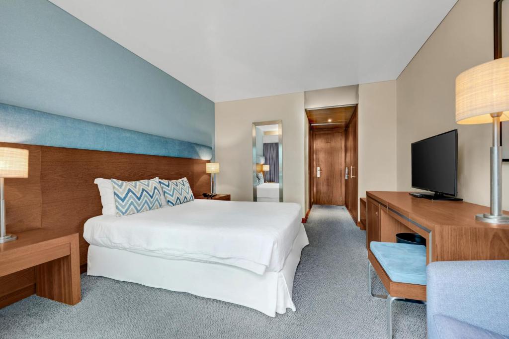 a hotel room with a bed and a television at Hotel Do Caracol in Angra do Heroísmo