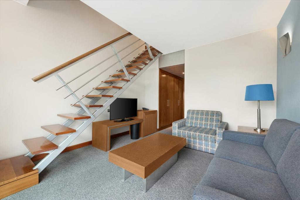 a living room with a couch and a staircase at Hotel Do Caracol in Angra do Heroísmo