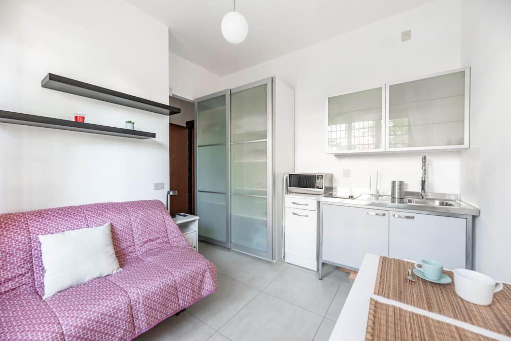 een woonkamer met een bank en een keuken bij enJoy Home - Piccolo monolocale zona Ospedale in Padua