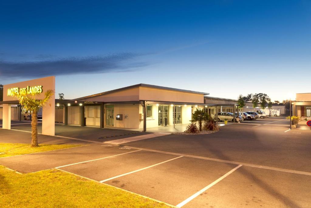 um parque de estacionamento vazio em frente a um edifício em Motel des Landes em Bénesse-Maremne