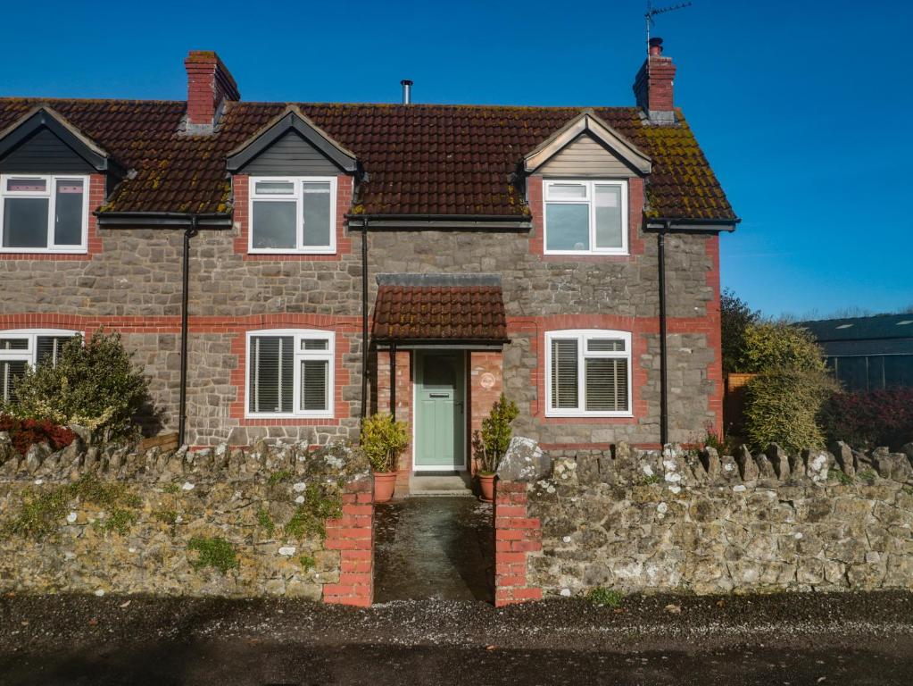 a red brick house with a stone fence at Coronation Cottages No 2 in Weston-super-Mare