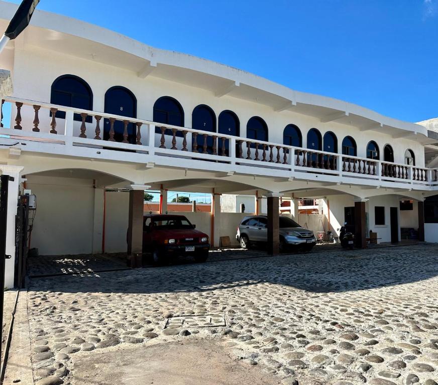 a large white building with cars parked in the driveway at Hotel San Andres in Chiquimulilla