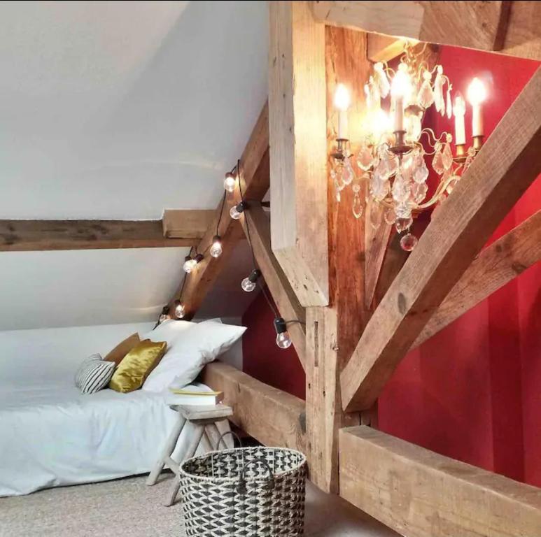 Cette chambre comprend un lit et un lustre. dans l'établissement Biarritz Beaurivage - Cote des Basques - Triplex, à Biarritz