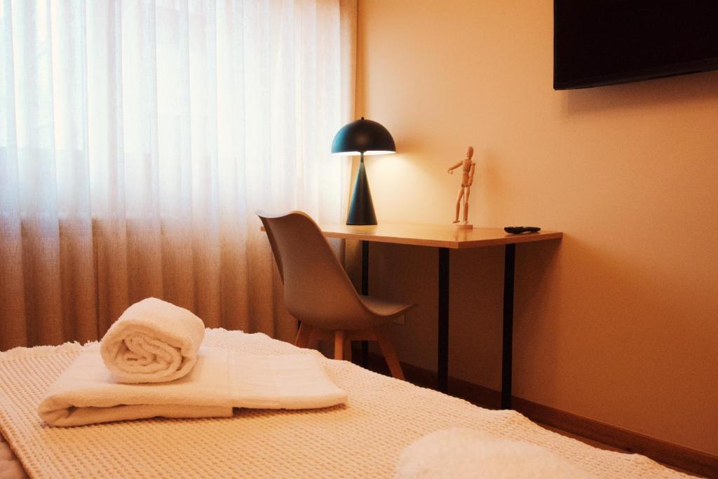 a room with a bed with a desk and a chair at Celorico Village AP in Celorico de Basto