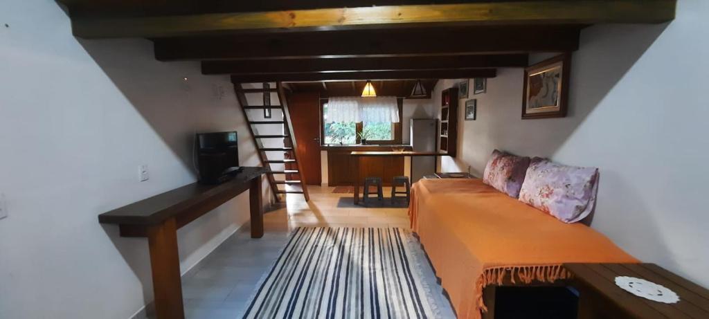 ein Wohnzimmer mit einem Sofa und einem Tisch in der Unterkunft Residencial Recanto Ferrugem in Garopaba