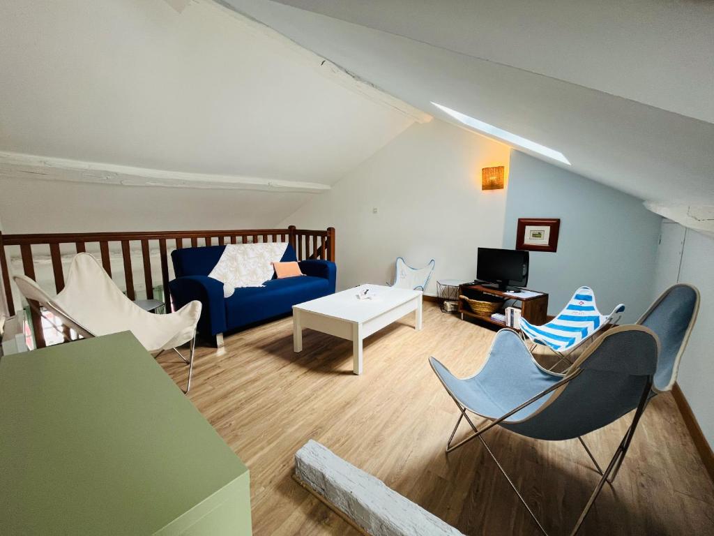 ein Wohnzimmer mit einem blauen Sofa und Stühlen in der Unterkunft Bayonne centre ville - Quartier historique in Bayonne