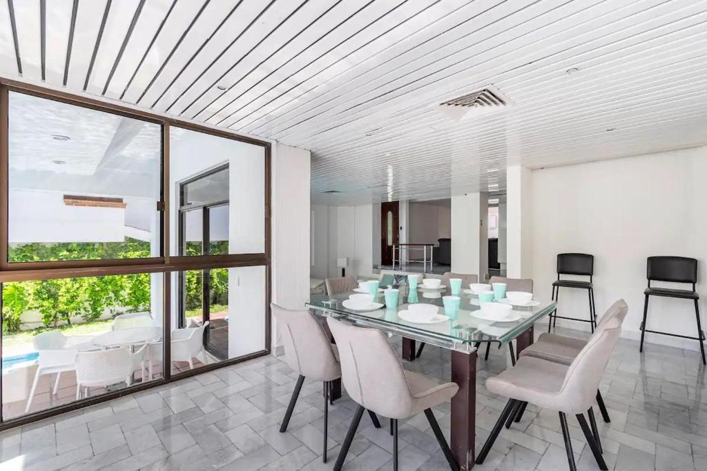 a dining room with a glass table and chairs at Beautiful Big House on a great strategic location in Cancún