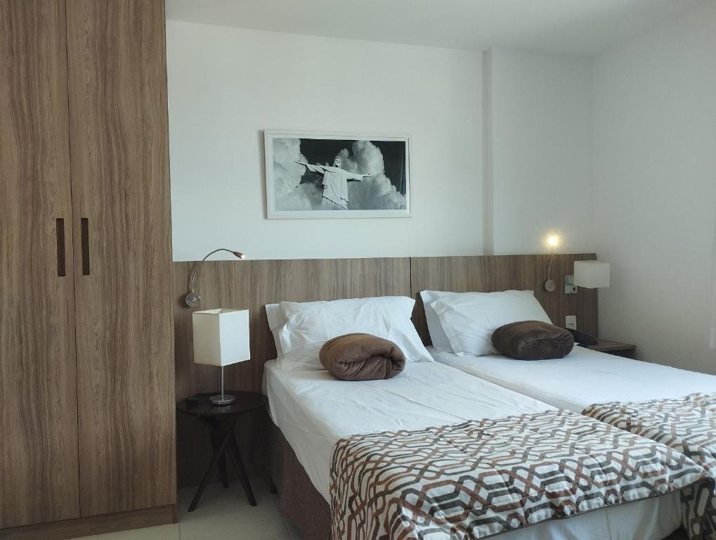 una camera con due letti con cuscini sopra di Terra Hospedagem Apartamento luxuoso Soho a Campos dos Goytacazes