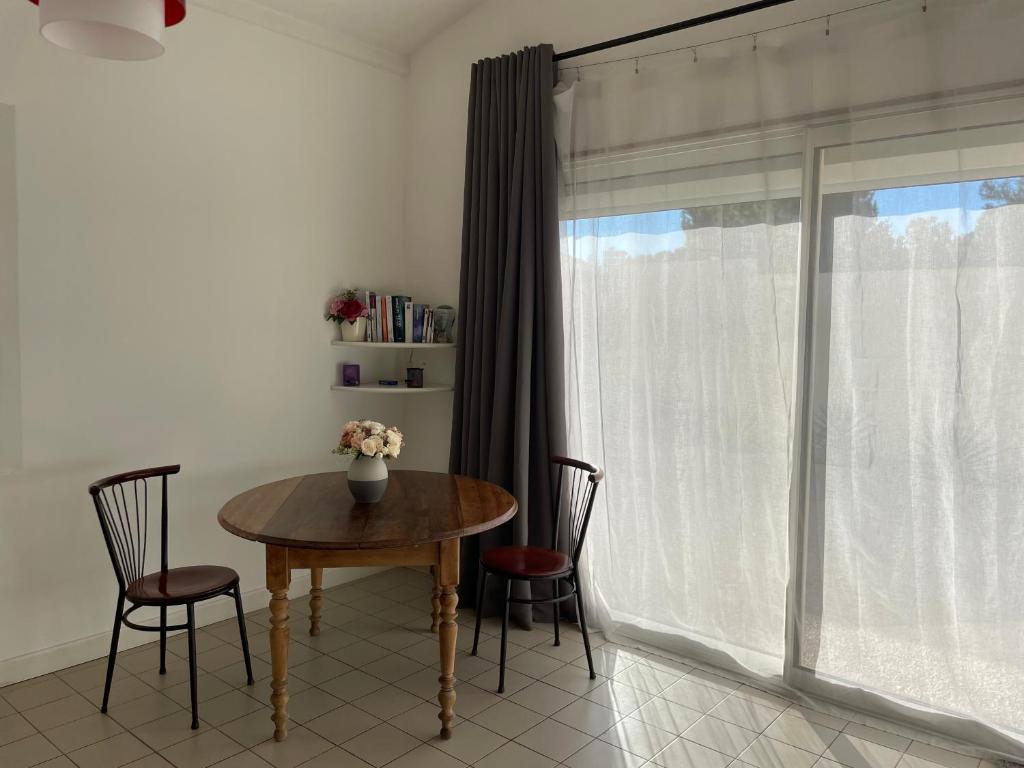 einen Tisch und Stühle in einem Zimmer mit Fenster in der Unterkunft Studio entre Aix et Marseille in Bouc-Bel-Air