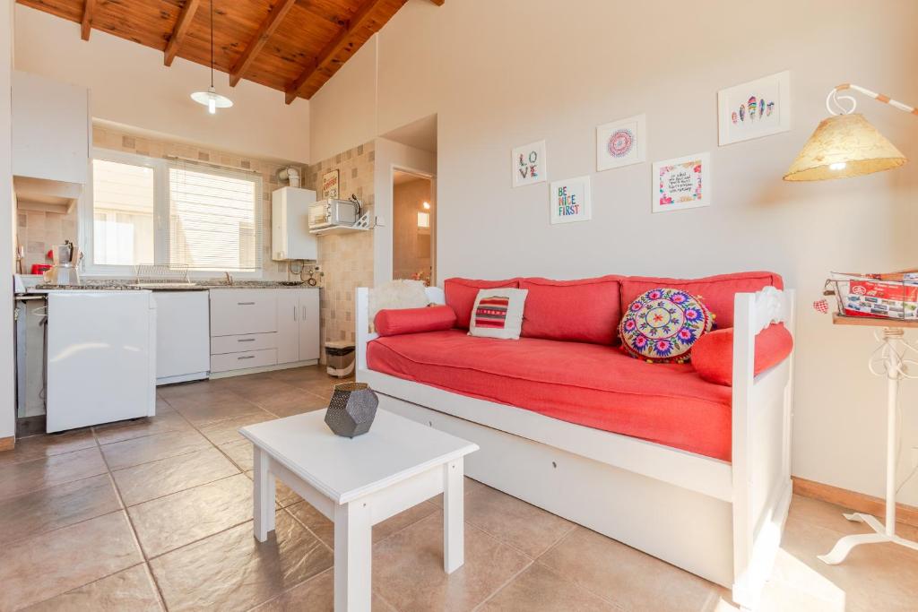 a living room with a red couch and a kitchen at Beautiful Apartment Downtown, Amazing Lake Views JF1 by Apartments Bariloche in San Carlos de Bariloche