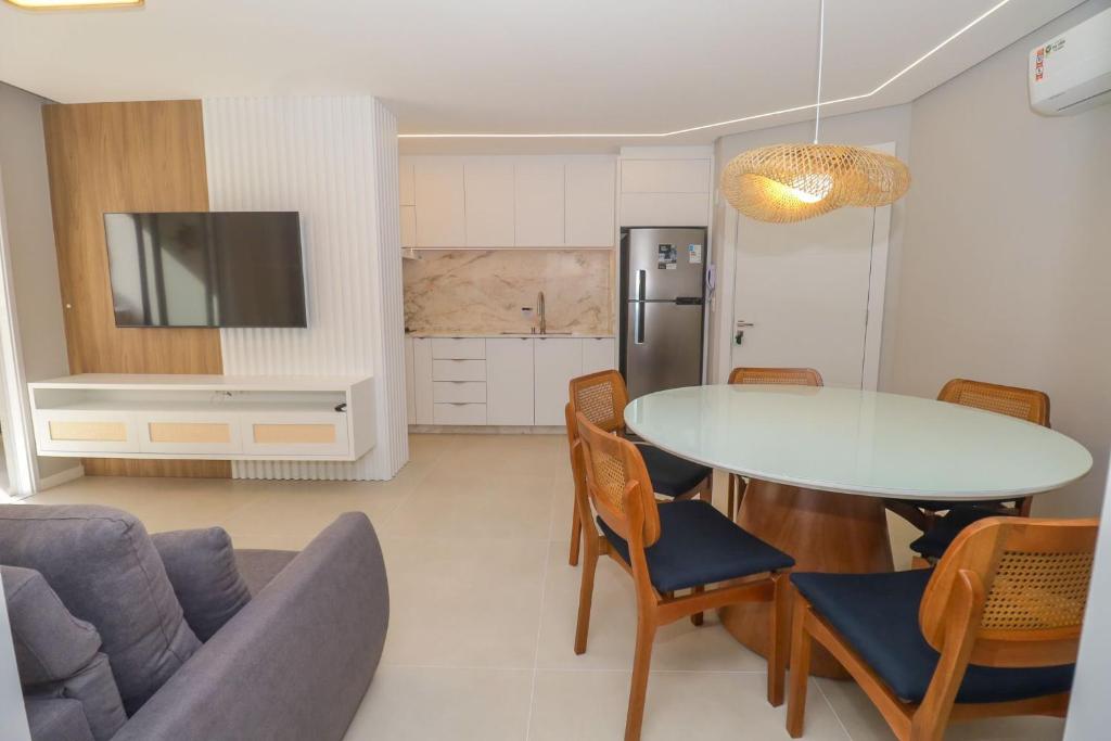 a kitchen and living room with a table and chairs at Nassau 203 - Excelente apartamento - Finamente mobiliado e decorado - À poucos metros da praia - (Consultar serviços de roupa de cama e banho) in Bombinhas