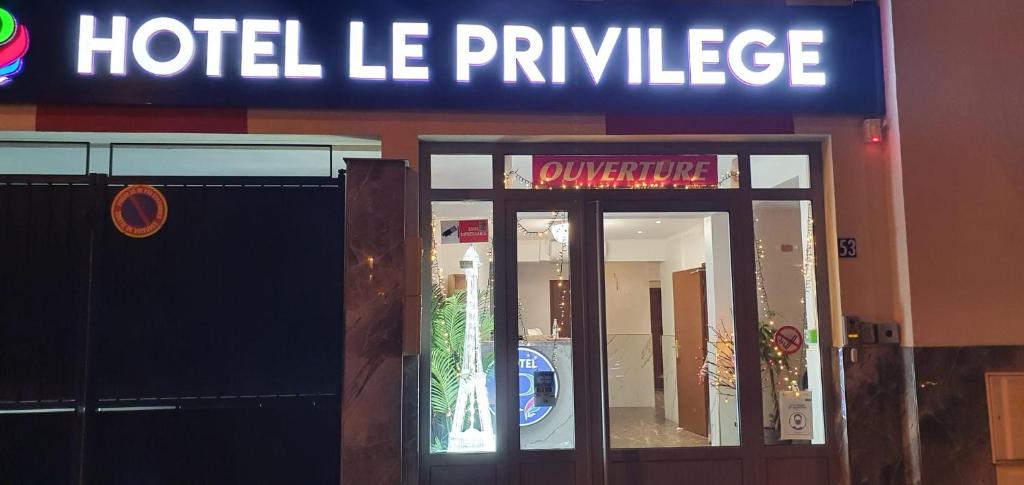 un cartel de hotel le Privilege frente a un edificio en Hotel le Privilege, en La Courneuve
