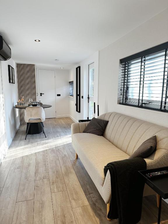 een woonkamer met een bank en een tafel bij Vakantiehuisje Noé in Gorinchem