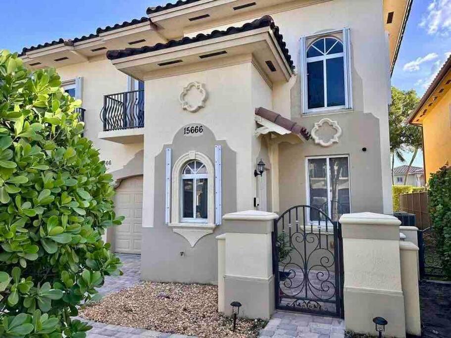 a white house with a gate in front of it at Spacious and cozy house in Miami in Tamiami