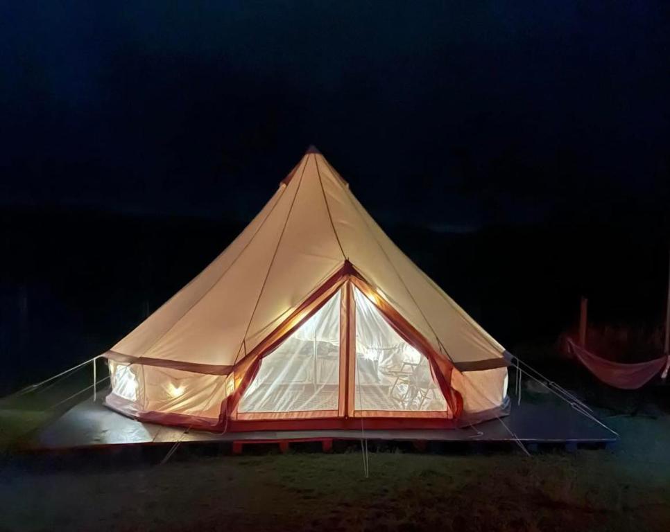 a tent is lit up in the dark at Maleka Farm: Tent Glamping North Shore Oahu in Laie