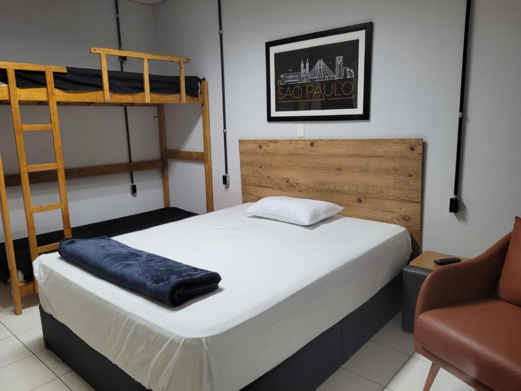 a bedroom with two bunk beds and a chair at Pousada Central in Bragança Paulista