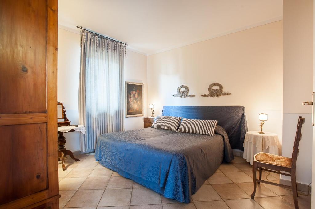 a bedroom with a blue bed and a table at Francesco Redi Camere in Arezzo