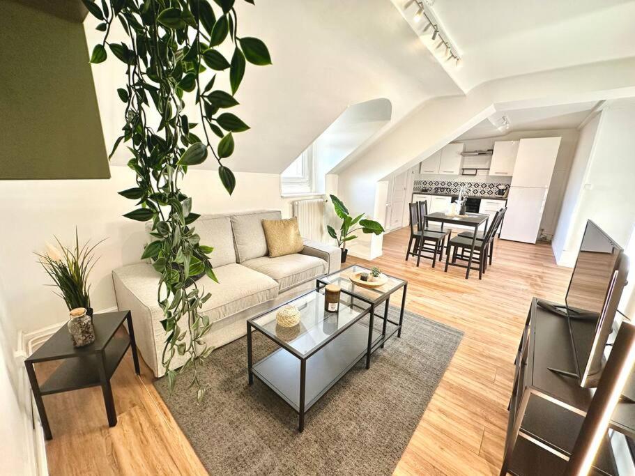 a living room with a couch and a table at Le Bois Tordu in Dijon