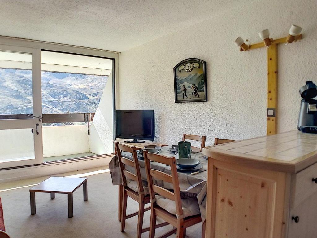 une cuisine avec une table et des chaises ainsi qu'une télévision dans l'établissement Studio duplex agréable Au pied des pistes Balcon - FR-1-344-921, aux Menuires