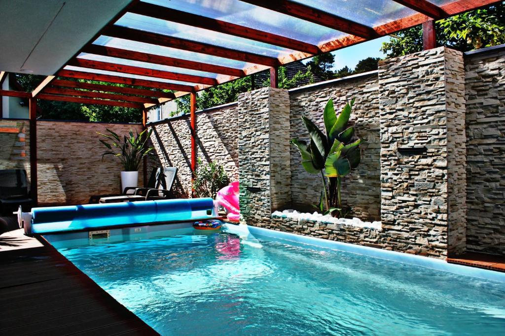 a swimming pool in a backyard with an umbrella at Willa Exotic in Łeba