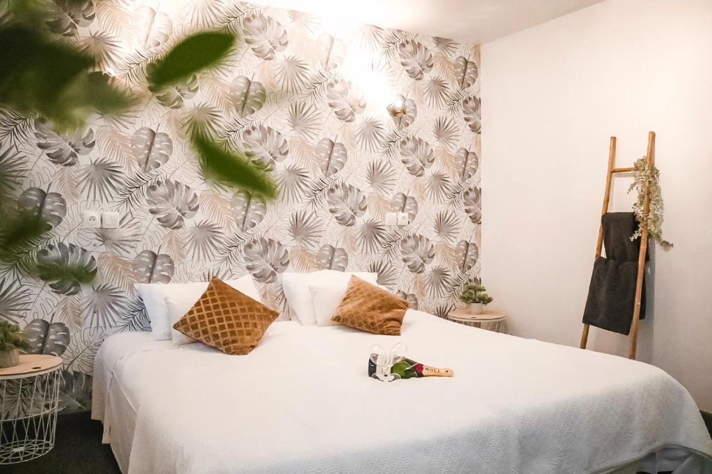 een slaapkamer met een wit bed en een muur bij Maria Grazia Hotel in Saint Gatien des Bois 