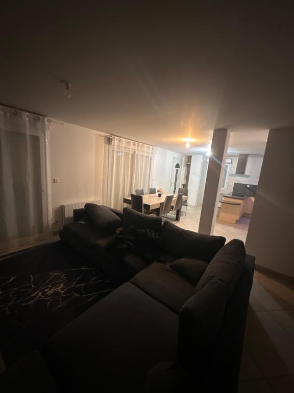 - un salon avec un canapé noir et une table dans l'établissement Appartement 8 personnes max, à Villelongue-de-la-Salanque