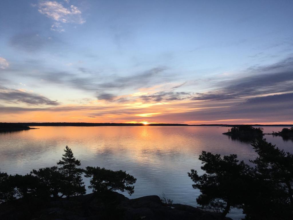 Ingmarsö的住宿－Cozy Cabin in Stockholms Archipelago，日落在一大片水面上