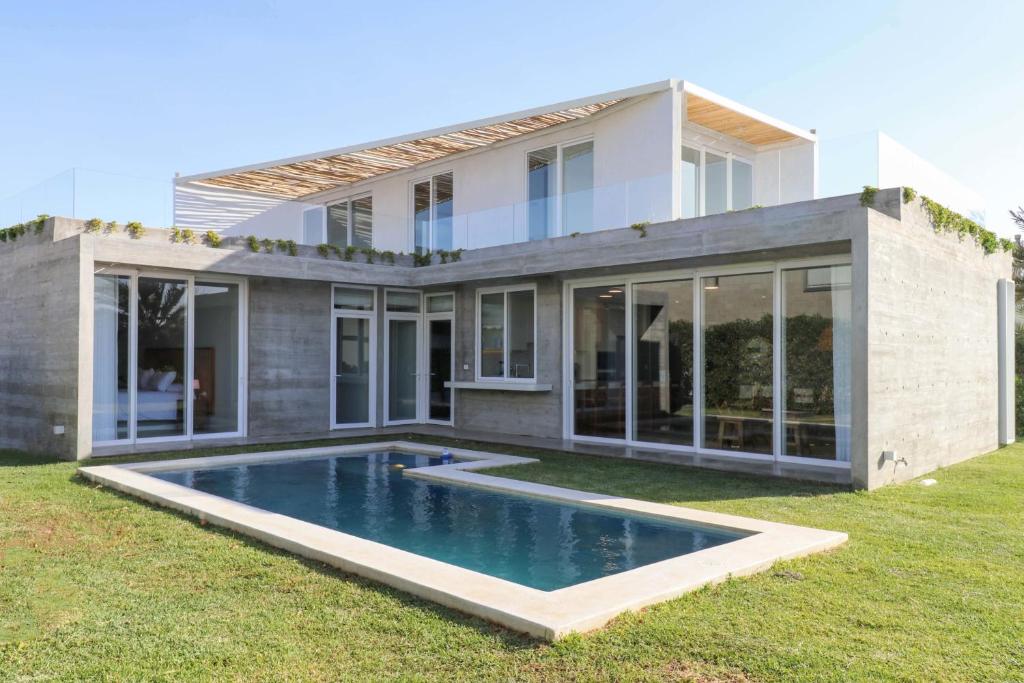 una casa con piscina frente a ella en Modern 4BR Villa with Private Pool in Paracas en Paracas