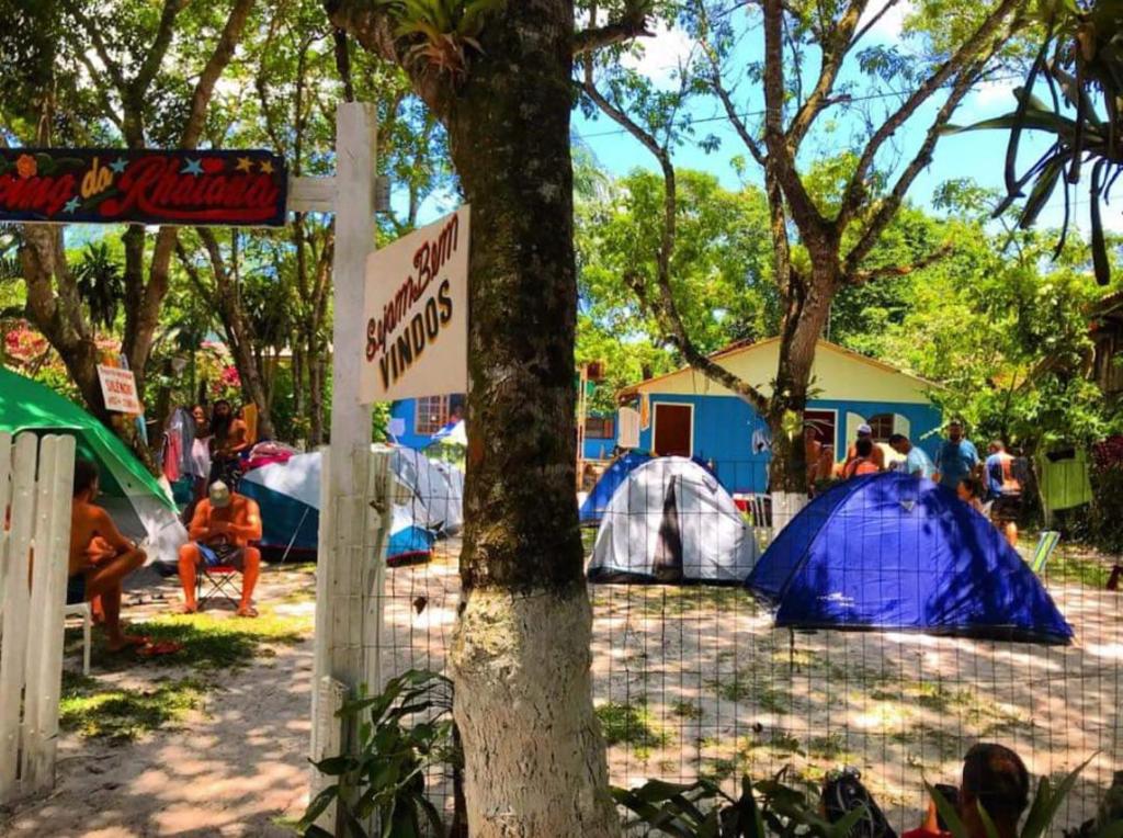 un grupo de tiendas de campaña en un campo con una señal en Pousada e Camping da Rhaiana - Ilha do Mel - PR, en Ilha do Mel