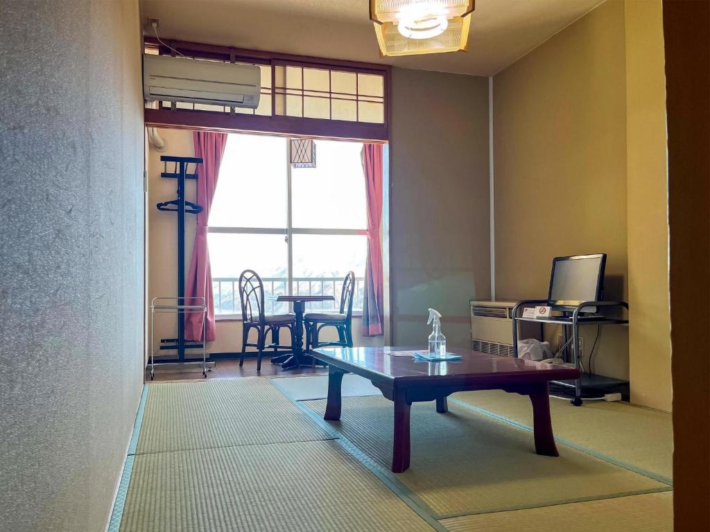 een woonkamer met een tafel en een raam bij Ishiuchi Ski Center - Vacation STAY 09196v in Seki