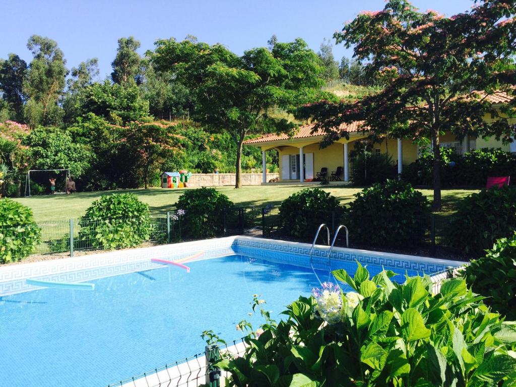 a swimming pool in front of a house at Quinta do Pinheiral in Favões