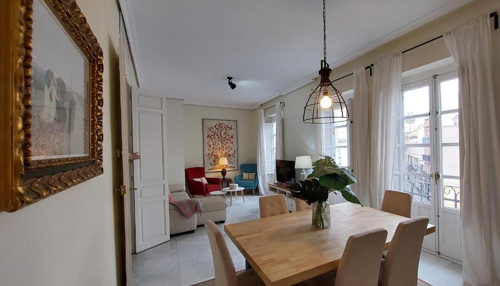 a dining room with a table and a living room at Magdalena Plaza City Center 2 in Seville