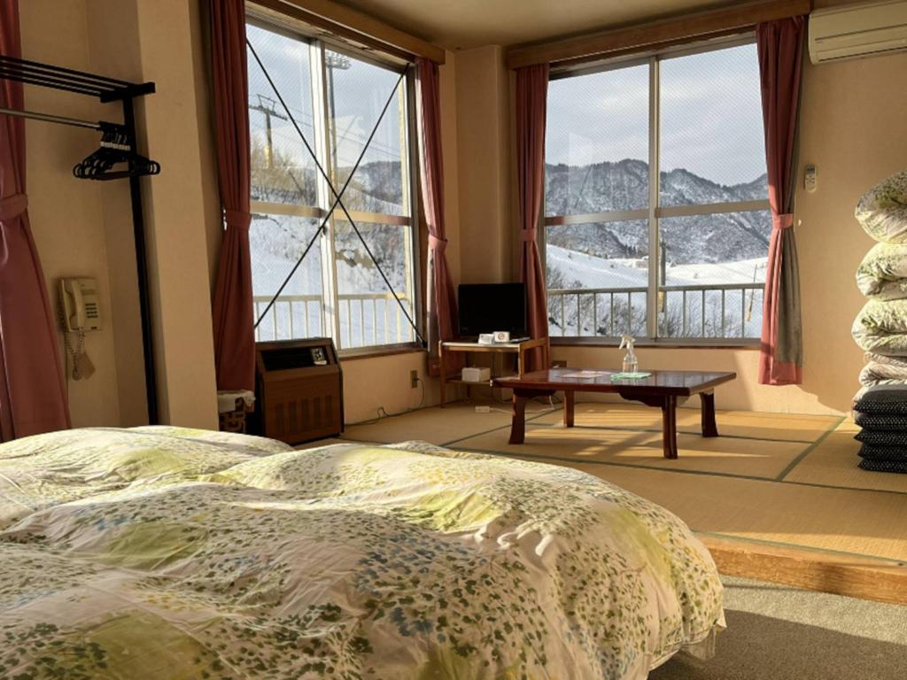 um quarto com uma cama, uma mesa e janelas em Ishiuchi Ski Center - Vacation STAY 09210v em Seki