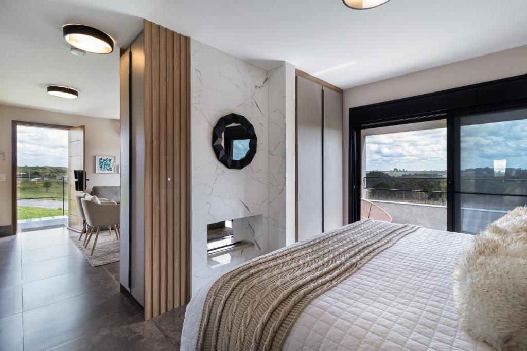 - une chambre avec un grand lit et une cheminée dans l'établissement Vale do Purunã Flats de Lazer, à Balsa Nova