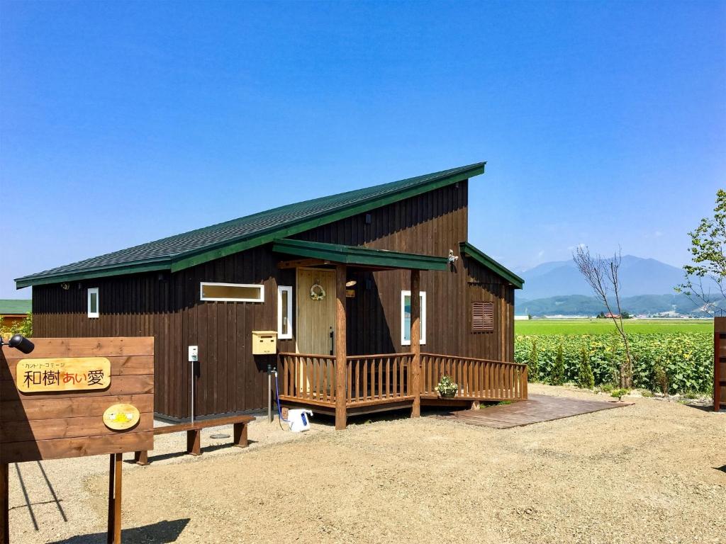 duży drewniany budynek z werandą na polu w obiekcie Country Cottage Waki Aiai - Vacation STAY 26548v w mieście Sorachi