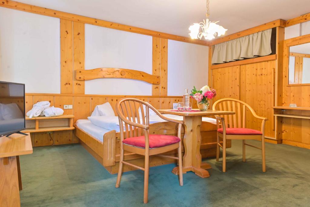 Cette chambre comprend un lit, une table et des chaises. dans l'établissement Ferienhotel Alber, à Mallnitz