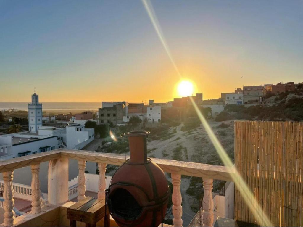 a vase sitting on a balcony with the sunset at DAR SANAE SURF in Aourir