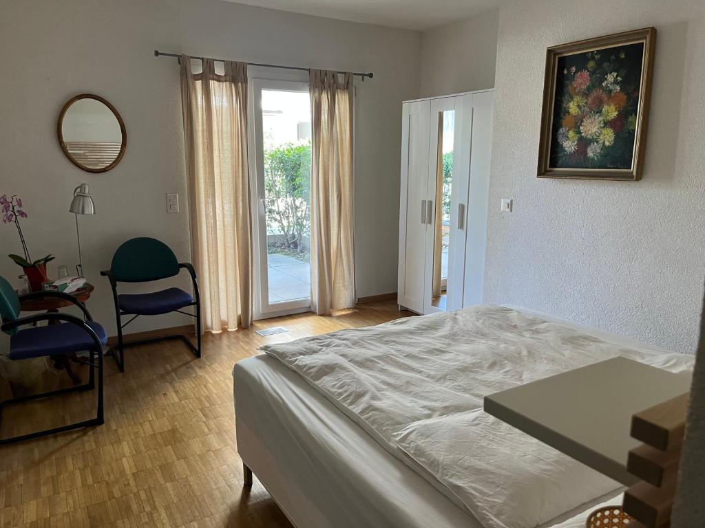een slaapkamer met een bed, een tafel en een stoel bij Grande chambre avec Salle de Bains Privative in Lausanne