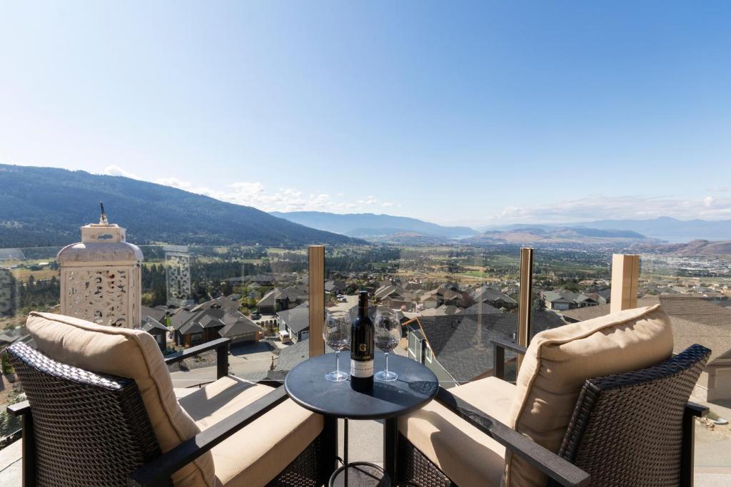 a table and chairs on a balcony with a bottle of wine at Stunning 5 bed house on Silver Star mountain in Vernon