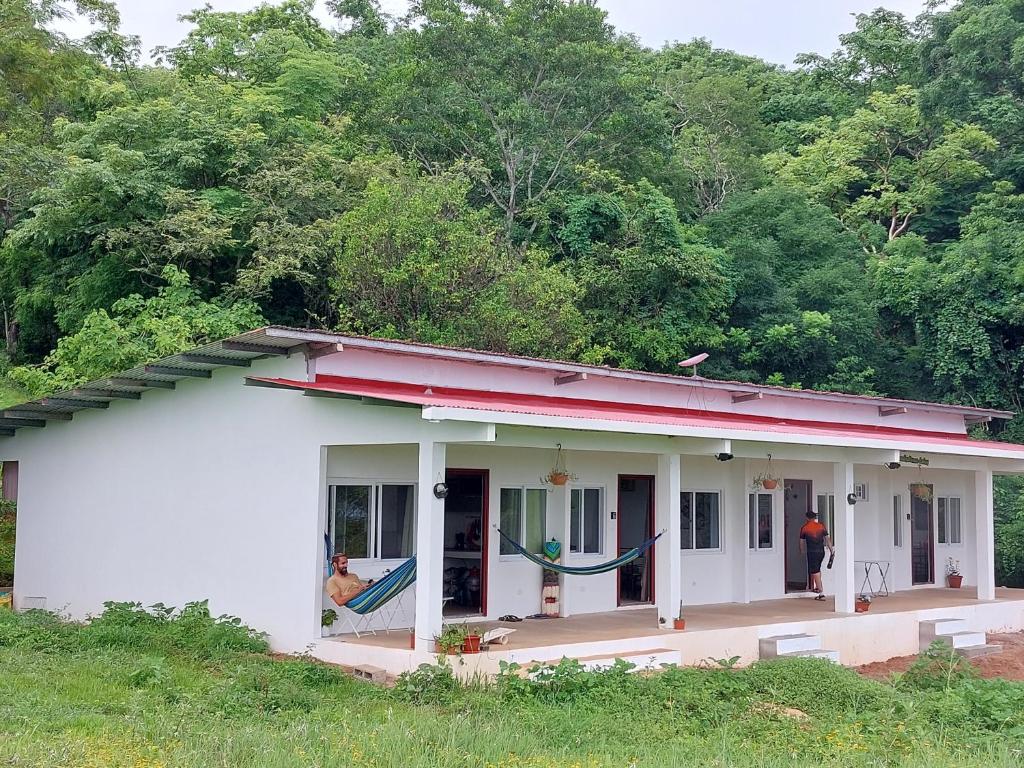 Biały dom z mężczyzną stojącym przed nim w obiekcie Paradise Venao - Cañas w mieście Cañas