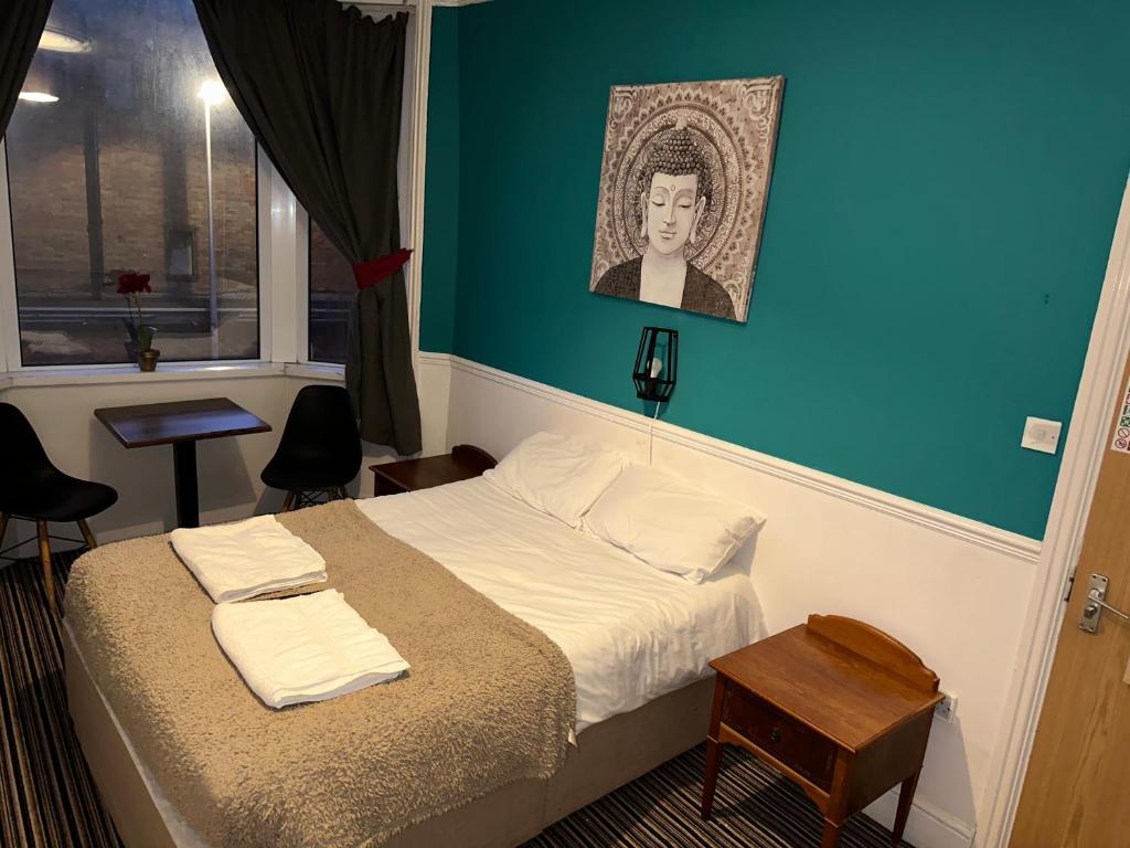 1 dormitorio con 1 cama con pared azul en The Northern Star en Blackpool