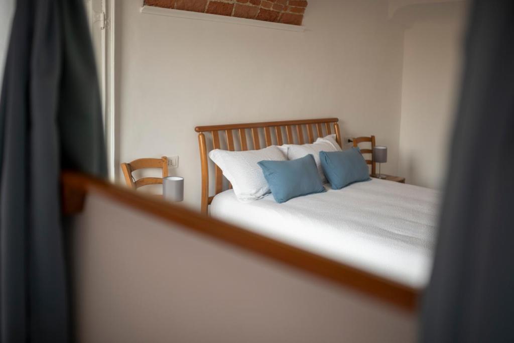 a bedroom with a bed with two blue pillows at Domus Antiche Mura in Asti