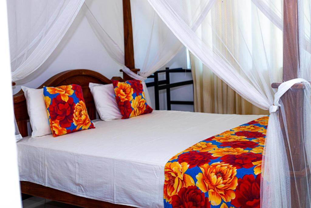 a bedroom with a bed with a colorful blanket at Sanasuma Hotel in Hambantota